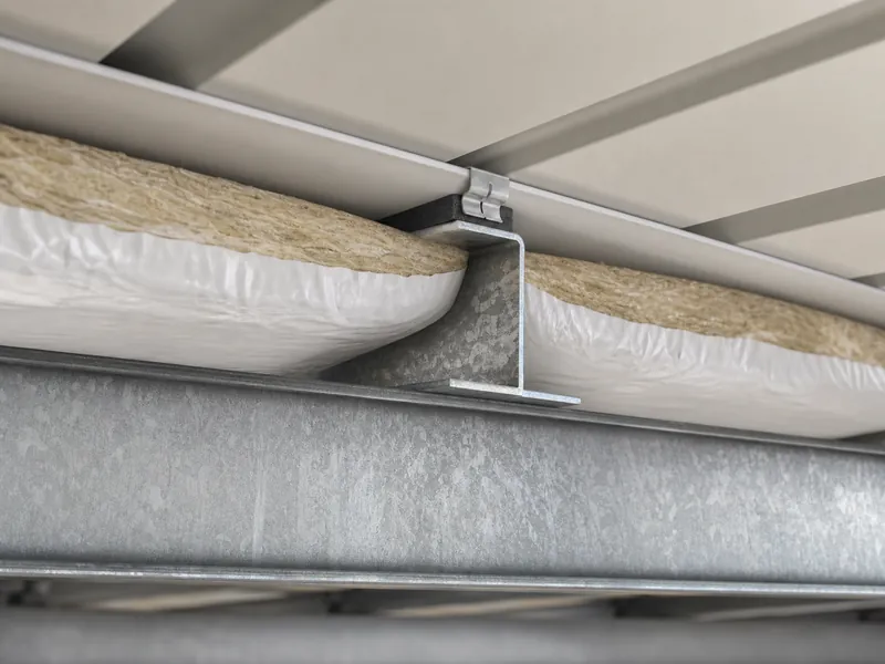 Insulation assembly and purlin detail at the roof of a customized steel warehouse building